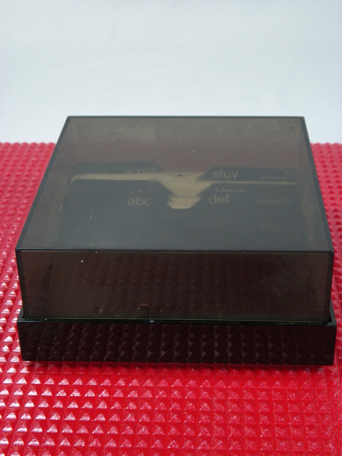 Black plastic square telephone directory with cardboard index cards and smoked cover, 1970s