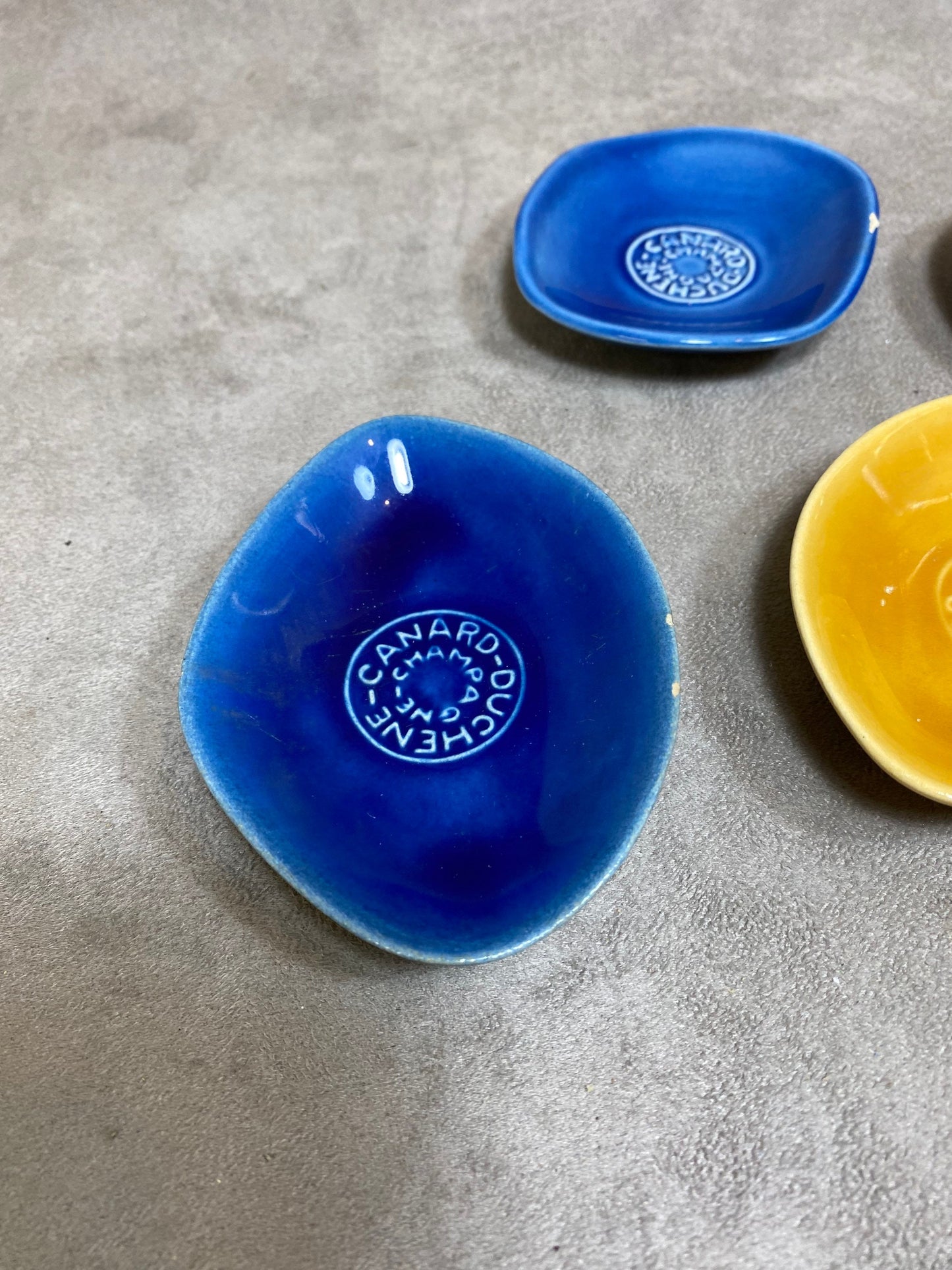 Set of 5 vintage Canard-Duchêne ashtrays in blue, red, yellow and green ceramic Made in France